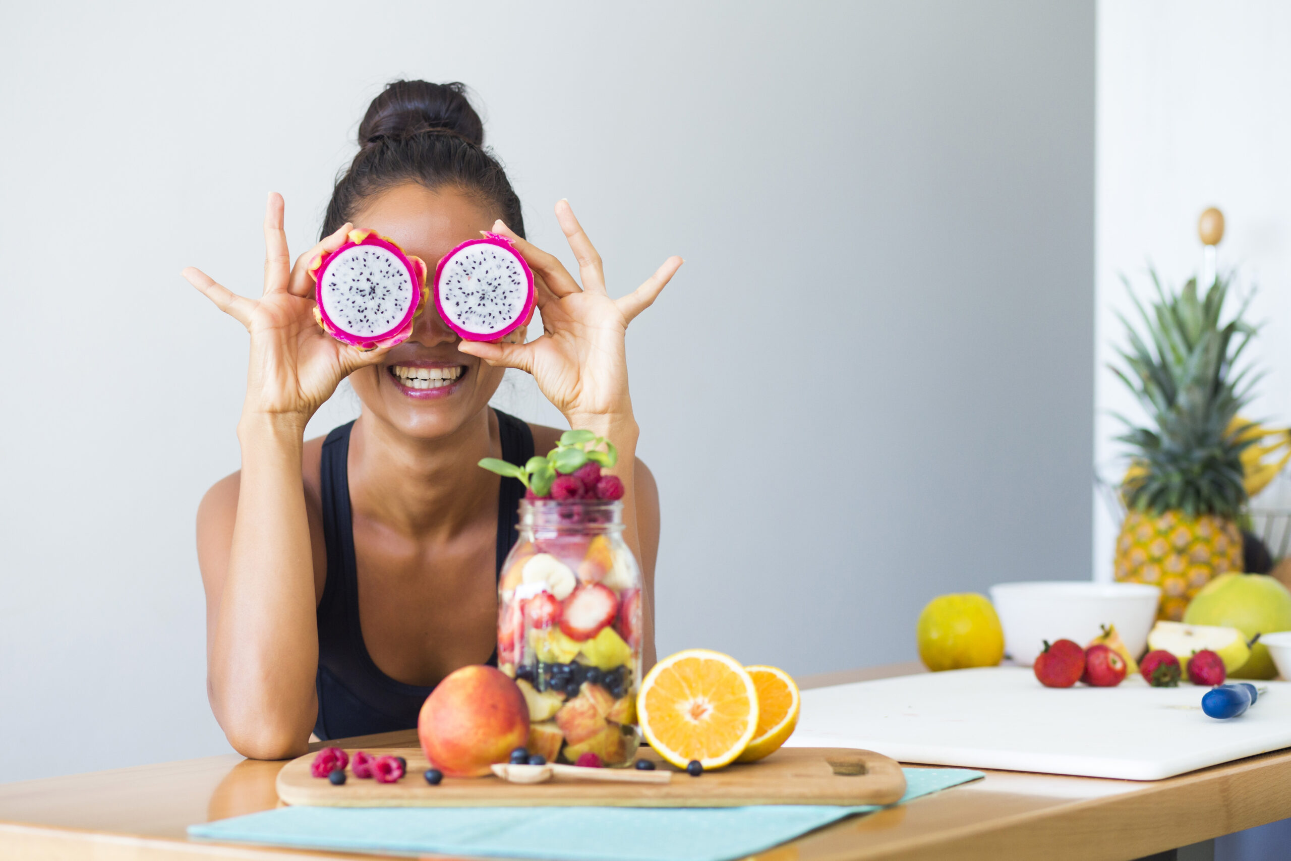 Woman,Smiling,With,A,Tropical,Fruit,Salad,,Being,Playful,Covering
