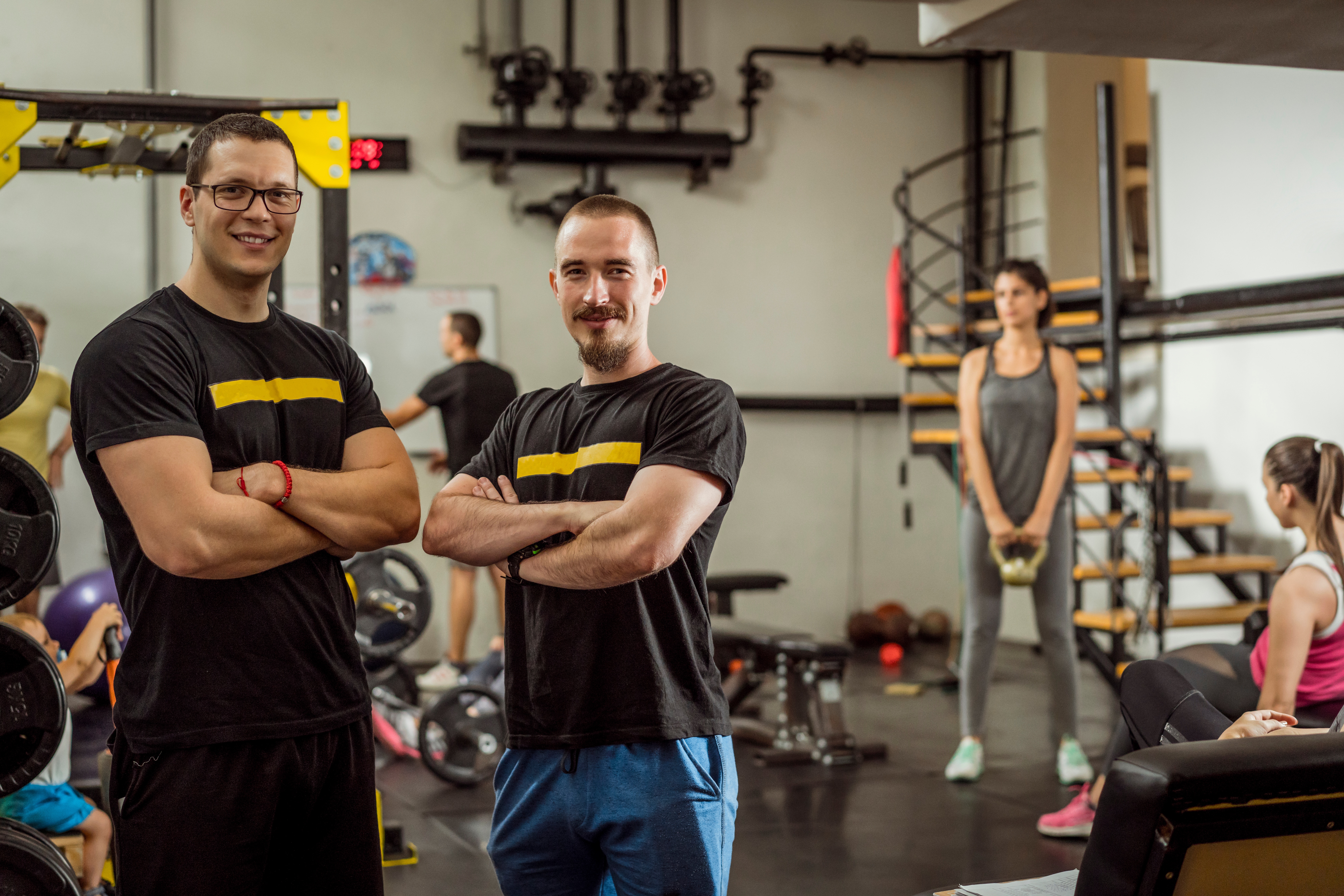 Two,Successful,Male,Personal,Trainers,And,Gym,Owners,In,Their Two successful male personal trainers and gym owners in their gym. Happy because their business is growing